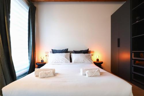 a bedroom with a large white bed with two pillows at Primopiano - Zumbini in Milan