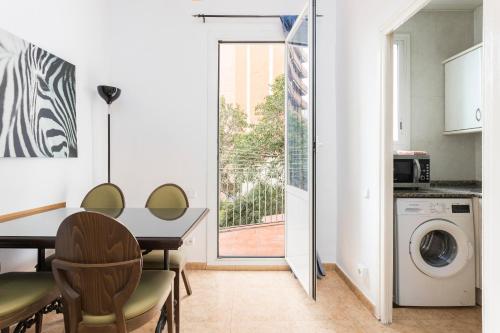 a kitchen and dining room with a table and a window at Apartaments Clot-Sant Martí in Barcelona