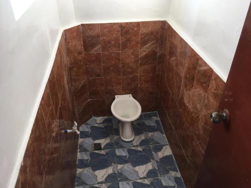 a small bathroom with a toilet in a stall at Sunset Beach House - Ground Floor in Matnog