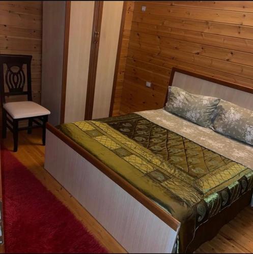 Llogara Chalet في Shalë: غرفة نوم بسرير مع كرسي وطاولة