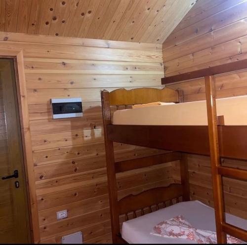 Llogara Chalet في Shalë: غرفة نوم مع سريرين بطابقين في كابينة