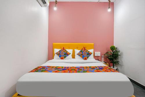 een slaapkamer met een groot bed met een geel hoofdeinde bij FabHotel Sky City in Surat