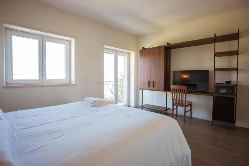 ポテンツァにあるTre cancelli roomsのベッドルーム(大きな白いベッド1台、椅子付)
