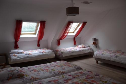 a room with three beds and two windows at Mère Elvira in Lourdes