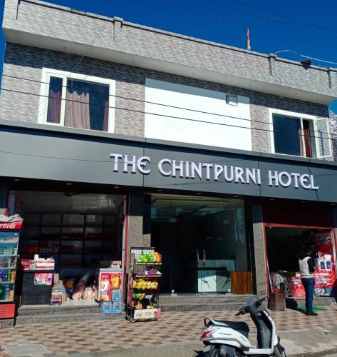 een motorfiets geparkeerd voor een winkel bij The Chintpurni Hotel in Katra