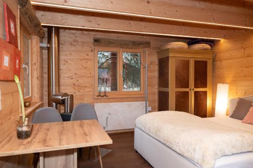 um quarto com uma cama, uma mesa e cadeiras em Kleines romantisches Chalet in der Semmering-Rax Region em Neunkirchen