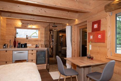 cocina y comedor con mesa y sillas en Kleines romantisches Chalet in der Semmering-Rax Region en Neunkirchen