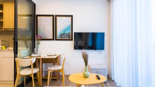 Il comprend un salon avec une table et une cuisine avec une télévision. dans l'établissement Laguna Skypark Апартаменты, à Bang Tao Beach