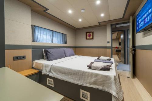un grande letto in una piccola camera con TV di Explorer Yacht a Fethiye