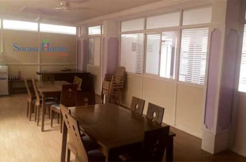 a dining room with tables and chairs and windows at Sucasa homes (HOME AWAY FROM HOME GUESTS SERVICES in Hyderabad