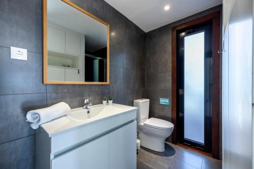 La salle de bains est pourvue d'un lavabo, de toilettes et d'un miroir. dans l'établissement Casa Kube, à Sagres