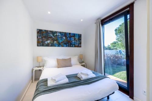 a bedroom with a bed with a large window at Casa Kube in Sagres