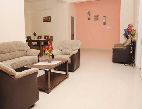 uma sala de espera com sofás e uma mesa num quarto em Sucasa homes (HOME AWAY FROM HOME GUESTS SERVICES em Hyderabad