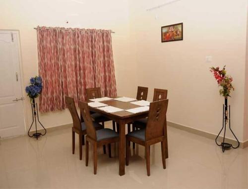 a dining room table and chairs in a room at Sucasa homes (HOME AWAY FROM HOME GUESTS SERVICES in Hyderabad