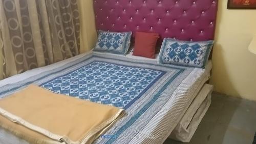 Una cama con cabecero púrpura y almohadas. en Blue Diamond Service Apartments, en Pune