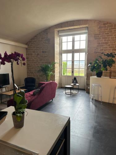 - un salon avec un canapé rouge et un mur en briques dans l'établissement Loft de charme avec terrasse et jardin au Fort d’Asfeld, à Sedan