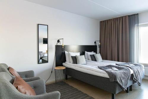 Habitación de hotel con cama y silla en Forenom Hotel Flemingsberg - 10min from Älvsjö en Huddinge