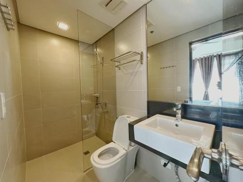 a bathroom with a toilet and a sink and a mirror at Coral Edge @ Boracay Newcoast in Boracay