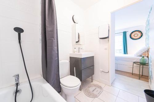 une salle de bain avec toilettes, lavabo et baignoire dans l'établissement F2 coloré et confortable proche Disney+WIFI, à Bailly-Romainvilliers
