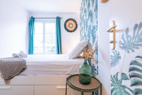 - une chambre avec un lit et une table avec un vase dans l'établissement F2 coloré et confortable proche Disney+WIFI, à Bailly-Romainvilliers