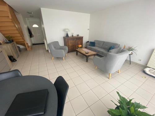 un salon avec un canapé, des chaises et une table dans l'établissement Maison 6 couchages Lormont proche tram, à Lormont