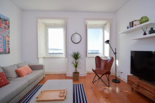 a living room with a couch and a tv at Casa Tejo in Cruz Quebrada