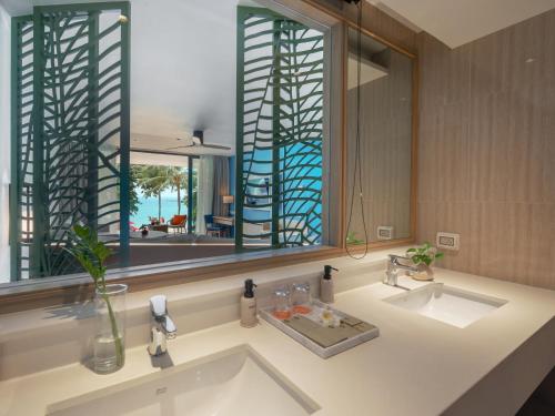 a bathroom with two sinks and a large mirror at Amari Koh Samui in Chaweng