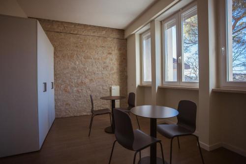 ein Zimmer mit 2 Tischen und Stühlen und einem Fenster in der Unterkunft Tre cancelli rooms in Potenza