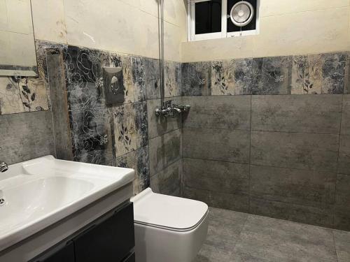 a bathroom with a toilet and a sink at 3 bed Luxurious Apartment DHA PH8 in Lahore
