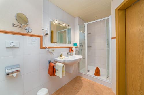 a bathroom with a sink and a shower at Gästehaus Linsinger in Bad Wiessee