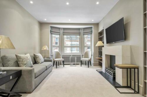 a living room with a couch and a fire place at Luxury Knightsbridge apartment outside Harrods in London