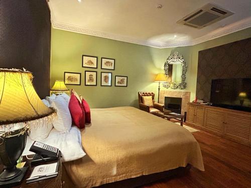 a bedroom with a large bed and a television at Ajit Bhawan - A Palace Resort in Jodhpur