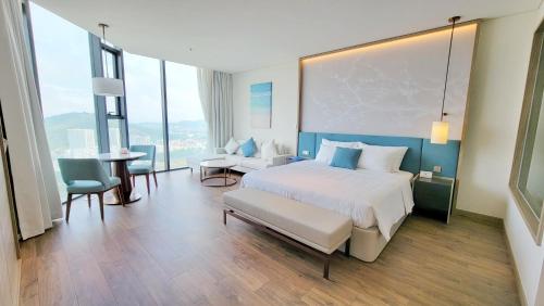 une chambre d'hôtel avec un lit, une table et des chaises dans l'établissement Luxury 5star Residence À La Carte HaLong Bay Floor 37, à Hạ Long