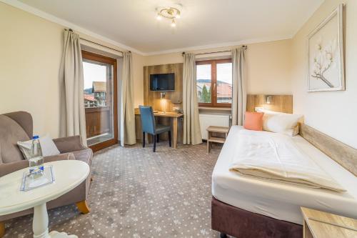 una habitación de hotel con una cama y una mesa en Gästehaus Linsinger, en Bad Wiessee