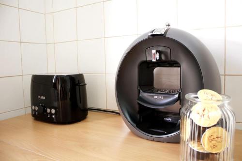 a coffee maker sitting on a counter next to a coffee pot at The Green Gate Patio House in Nazaré