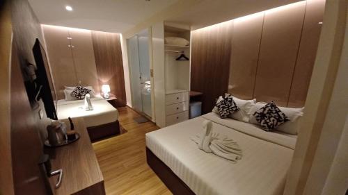 a small room with two beds and a mirror at MS Hotel Kuala Lumpur in Kuala Lumpur