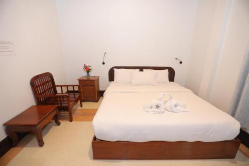 a bedroom with a bed with two swans on it at Villa KiengKham晶康民宿 in Luang Prabang