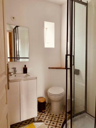 une salle de bain avec toilettes, lavabo et miroir dans l'établissement Mignon et cosy à côté de la mer, à Mers-les-Bains