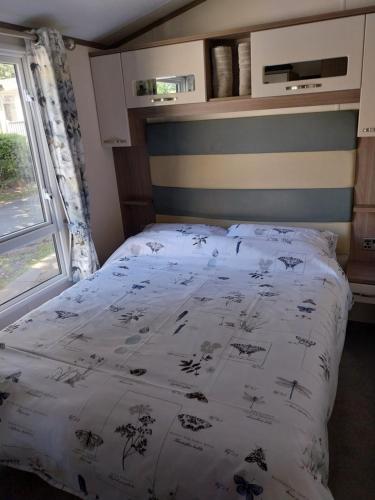 een slaapkamer met een bed met een wit dekbed bij Family breaks at Rockley Park with Prosecco and a box of chocolates on arrival in Poole