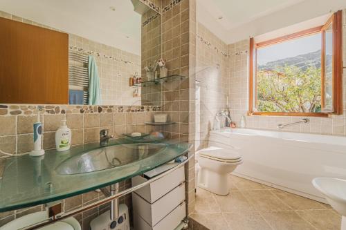 ein Bad mit einem Waschbecken, einem WC und einem Fenster in der Unterkunft Villa Lucia Comfort e Relax in Marciana Marina in Marciana Marina