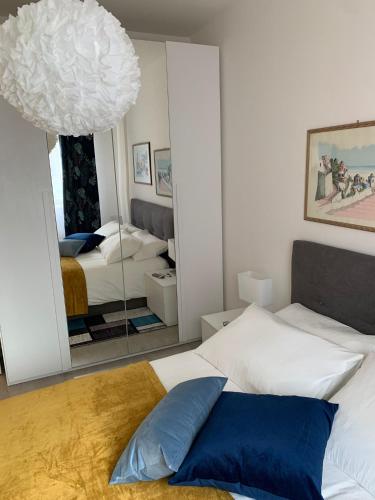 泰爾米尼伊梅雷塞的住宿－Albachiara Termini，卧室配有白色的床和镜子