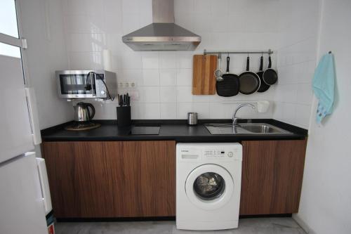 a kitchen with a washing machine and a sink at Apartamento Corazón de Triana in Seville