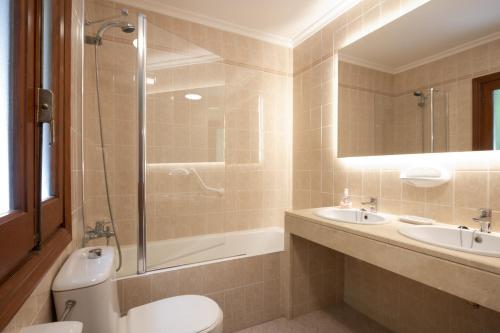 Un baño con inodoro, lavabo y ducha. en Villa MAESO, en Son Bou