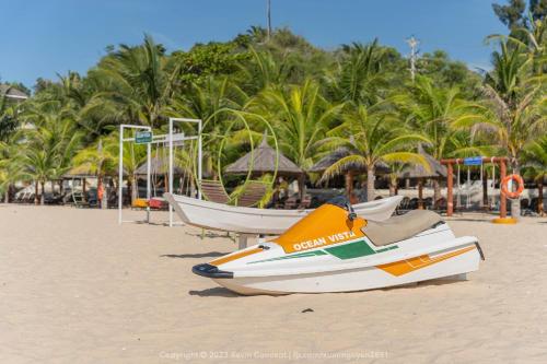 a couple of boats sitting on the beach at Ocean View Phan Thiết - Ocean Vista & SeaLink Mũi Né in Phan Thiet