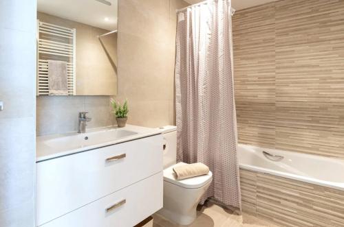 Un baño con inodoro, lavabo y bañera. en Beach terraced house close town, en Fuengirola