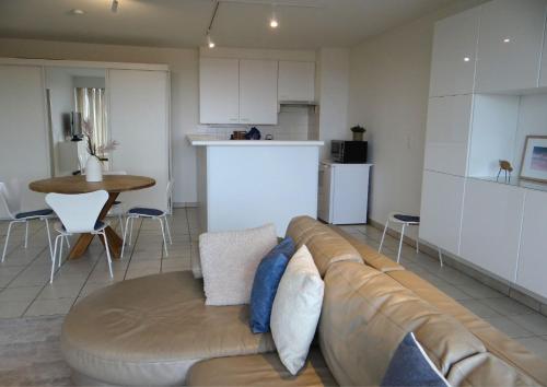 a living room with a couch and a kitchen at Kom tot rust in een heerlijk verblijf - Toplocatie met zonneterras! in Nieuwpoort