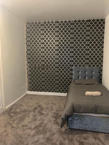 a bedroom with a bed and a accent wall at Single Room in Oldham
