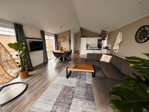 a living room with a couch and a table at Exclusieve vakantievilla ***** Markermeer in Bovenkarspel