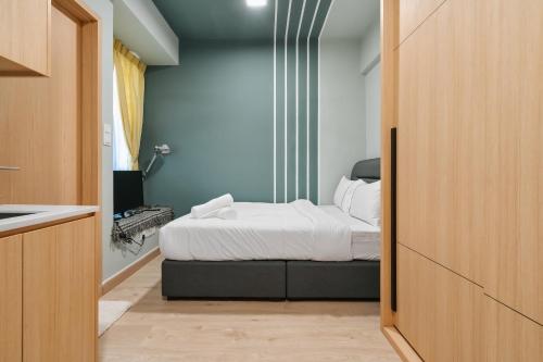 a bedroom with a bed with white sheets at Colony by Infinitum - 10mins to LRT Station in Kuala Lumpur