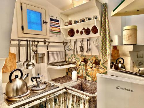 a kitchen with a sink with a tea kettle on it at Casetta Giorgia in Ostuni